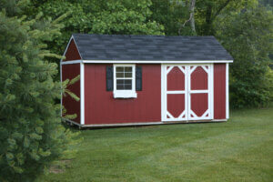 A red storage shed in the lawn